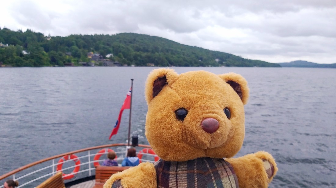 Scotty Bear is on a cruise boat on Lake Windermere under an overcast sky